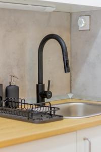 a kitchen sink with a black faucet next to a sink at Eszter's cozy apartment in Budapest