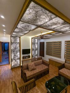 un soggiorno con divani e TV a schermo piatto di Grand Villa Houseboat a Kumarakom