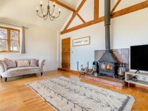 a living room with a couch and a fireplace at 4 Bed in Bishops Offley 93215 in Eccleshall