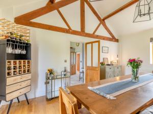 a dining room with a wooden table and a kitchen at 4 Bed in Bishops Offley 93215 in Eccleshall