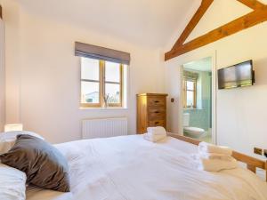 ein Schlafzimmer mit einem großen weißen Bett und einem Spiegel in der Unterkunft 4 Bed in Bishops Offley 93215 in Eccleshall