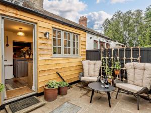 a tiny house with a patio with two chairs and a table at 2 Bed in Hay-on-Wye 93221 in Hay-on-Wye