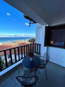 阿吉奧斯伊歐尼斯的住宿－Aegean View House，阳台配有桌椅,享有海景。
