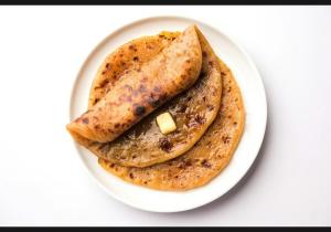 three pancakes on a white plate on a table at jai maa in swaraj lodge in Navi Mumbai
