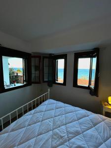 a bedroom with a bed with a view of the ocean at Aegean View House in Agios Ioannis Pelio
