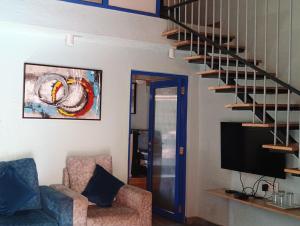 a living room with a staircase and a television at Hotel Panorama Resorts in Mahabaleshwar