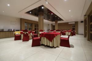 a banquet hall with red and gold tables and chairs at HOTEL YATRI in Nagpur