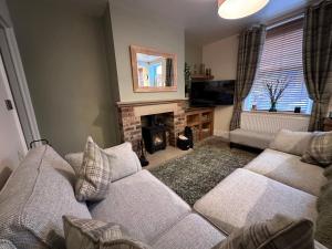 sala de estar con sofá y chimenea en Prince Street Cottage - Haworth - Sleeps 4, en Haworth