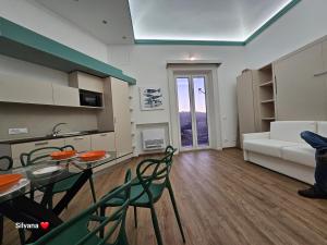 - un salon avec une table, des chaises et un canapé dans l'établissement Villa Di Giorgi Apartments Center, à Cefalù