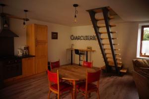 a dining room with a table and chairs and a staircase at belle maison de campagne in Hénon