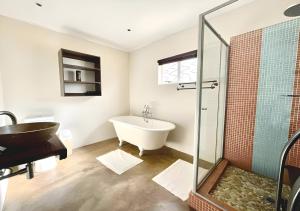 y baño con bañera y lavamanos. en KZN Park View Guest House, en Durban