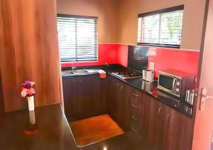 cocina con encimera negra y microondas en KZN Park View Guest House, en Durban
