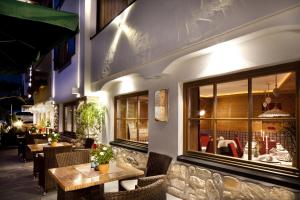 a restaurant with tables and chairs in front of a building at Hotel Christian in Corvara in Badia