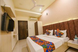 a bedroom with a bed and a flat screen tv at FabExpress Seven Heaven in New Delhi