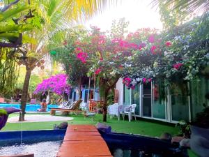 a house with a garden with pink flowers at OASIS Phuket Airport in Ban Bo Sai Klang