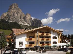un hotel con una montagna sullo sfondo di Hotel Christian a Corvara in Badia