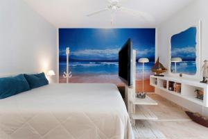 a bedroom with a large white bed and a television at Pardelo in Los Menores