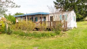 ein kleines Haus mit einem blauen Dach auf einem Feld in der Unterkunft Camping Nature et insolite proche Disneyland in Saâcy-sur-Marne