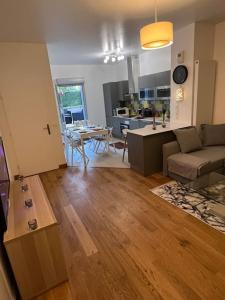 a living room with a couch and a table and a kitchen at T2 à 15mn stade de France Porte de Paris in Épinay-sur-Seine