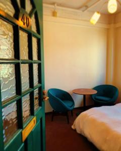 Zimmer mit einem Bett, 2 Stühlen und einem Tisch in der Unterkunft HOSTEL CHILLAX in Osaka