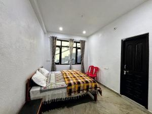 ein Schlafzimmer mit einem Bett und einem roten Stuhl in der Unterkunft Tulsi Homestay in Munsyari