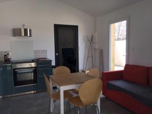 ein Wohnzimmer mit einem Tisch, Stühlen und einem Sofa in der Unterkunft Maison rénovée au calme in Gujan-Mestras
