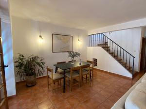 a dining room with a table and chairs and a staircase at Fuengirola pueblo 2BRD townhouse in Fuengirola