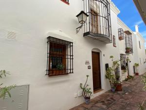 - un bâtiment blanc avec deux fenêtres et une porte dans l'établissement Fuengirola pueblo 2BRD townhouse, à Fuengirola