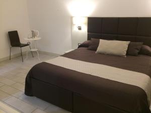 a bedroom with a large bed and a chair at Ape in Marina di Schiavonea