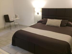 ein Schlafzimmer mit einem großen Bett und einem Stuhl in der Unterkunft Ape in Marina di Schiavonea