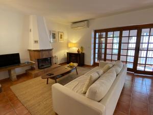 a living room with a white couch and a fireplace at Fuengirola pueblo 2BRD townhouse in Fuengirola