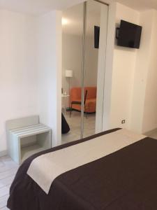 a bedroom with a bed and a chair and a mirror at Ape in Marina di Schiavonea