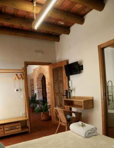 ein Schlafzimmer mit einem Bett und ein Zimmer mit einem Spiegel in der Unterkunft casa rural Cieza de León in Llerena