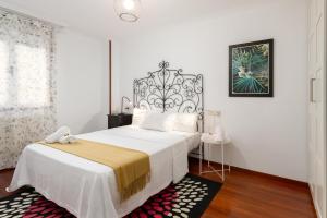 1 dormitorio con 1 cama grande y cabecero blanco y negro en Luisa Gijon, en Gijón