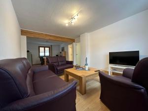 un salon avec des canapés et une télévision à écran plat dans l'établissement Ferienhaus Ginkgo Biloba, à Malsbenden