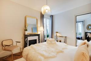 um quarto com uma cama, um espelho e uma lareira em Suite Haussmann by Les Maisons de Charloc Homes em Paris
