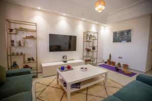 Majorelle Splendide Appartement في مراكش: غرفة معيشة مع أريكة وطاولة
