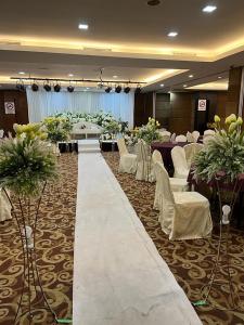 einen Bankettsaal mit weißen Stühlen, Tischen und Blumen in der Unterkunft Sunflower World Hotel in Kuala Selangor