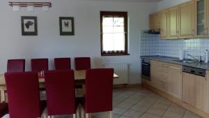 a kitchen with a wooden table and red chairs at FerienVilla Nimori in Lipno nad Vltavou