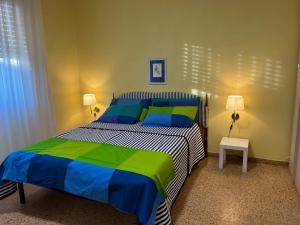 ein Schlafzimmer mit einem Bett in Blau und Grün in der Unterkunft Casa tra gli ulivi vicino al mare in Seravezza