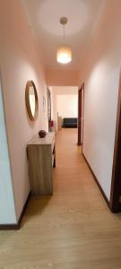 a hallway with a table and a mirror on the wall at Residencial Monaco in Funchal