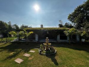 un giardino con fontana di fronte a una casa di Vijushbhuvi a Manesar