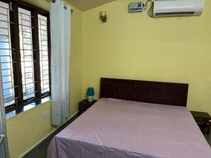 una camera da letto con un letto con copriletto viola e finestre di Vijushbhuvi a Manesar
