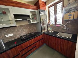 una cucina con un lavello e un piano di lavoro di Vijushbhuvi a Manesar