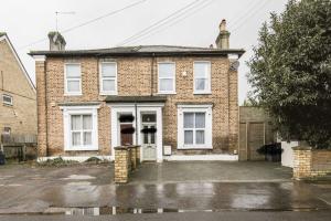 a brick house with white windows on a street at Spacious 4 bed house in Croydon w/ parking for x2 cars! - Photo ID required in South Norwood