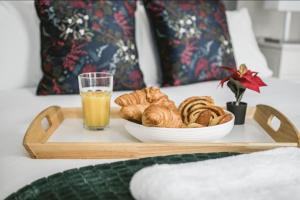 a tray with a plate of pastries and a glass of orange juice at Spacious 4 bed house in Croydon w/ parking for x2 cars! - Photo ID required in South Norwood