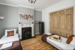 a bedroom with two beds and a fireplace at Spacious 4 bed house in Croydon w/ parking for x2 cars! - Photo ID required in South Norwood