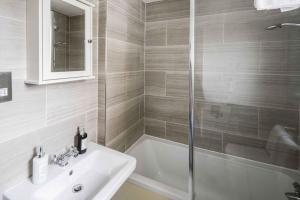 a bathroom with a sink and a bath tub at Spacious 4 bed house in Croydon with parking for x2 cars! - Photo ID Required in South Norwood +18 photos