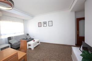 ein Wohnzimmer mit einem Sofa und einem Tisch in der Unterkunft Acogedor apartamento valencia 3 dormitorios in Aldaia