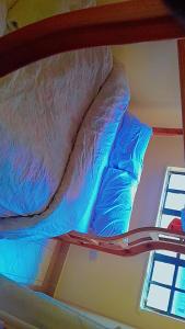 a bunk bed with blue and white sheets on it at great wall in Nairobi